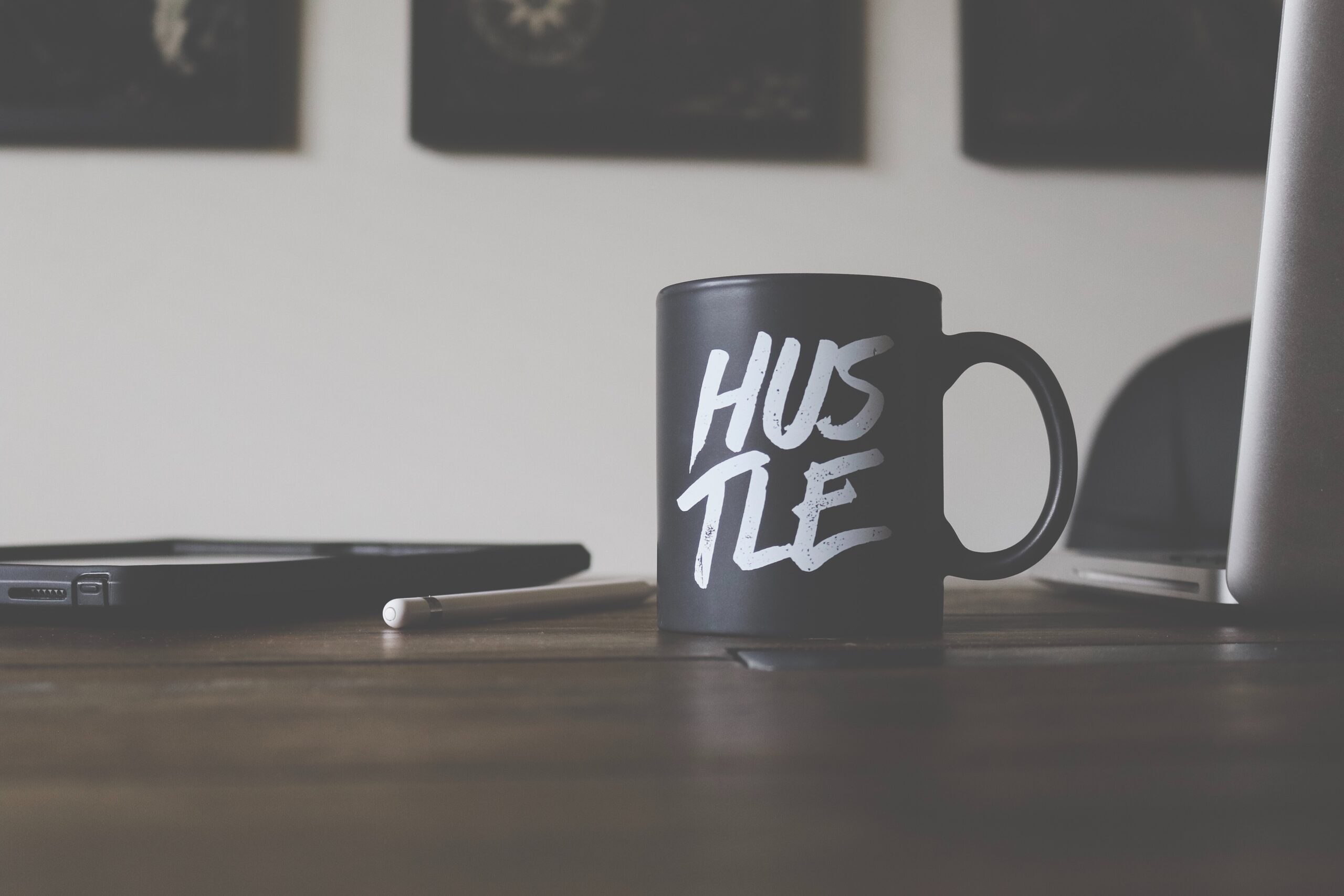 coffee mug with the word hustle on business desk